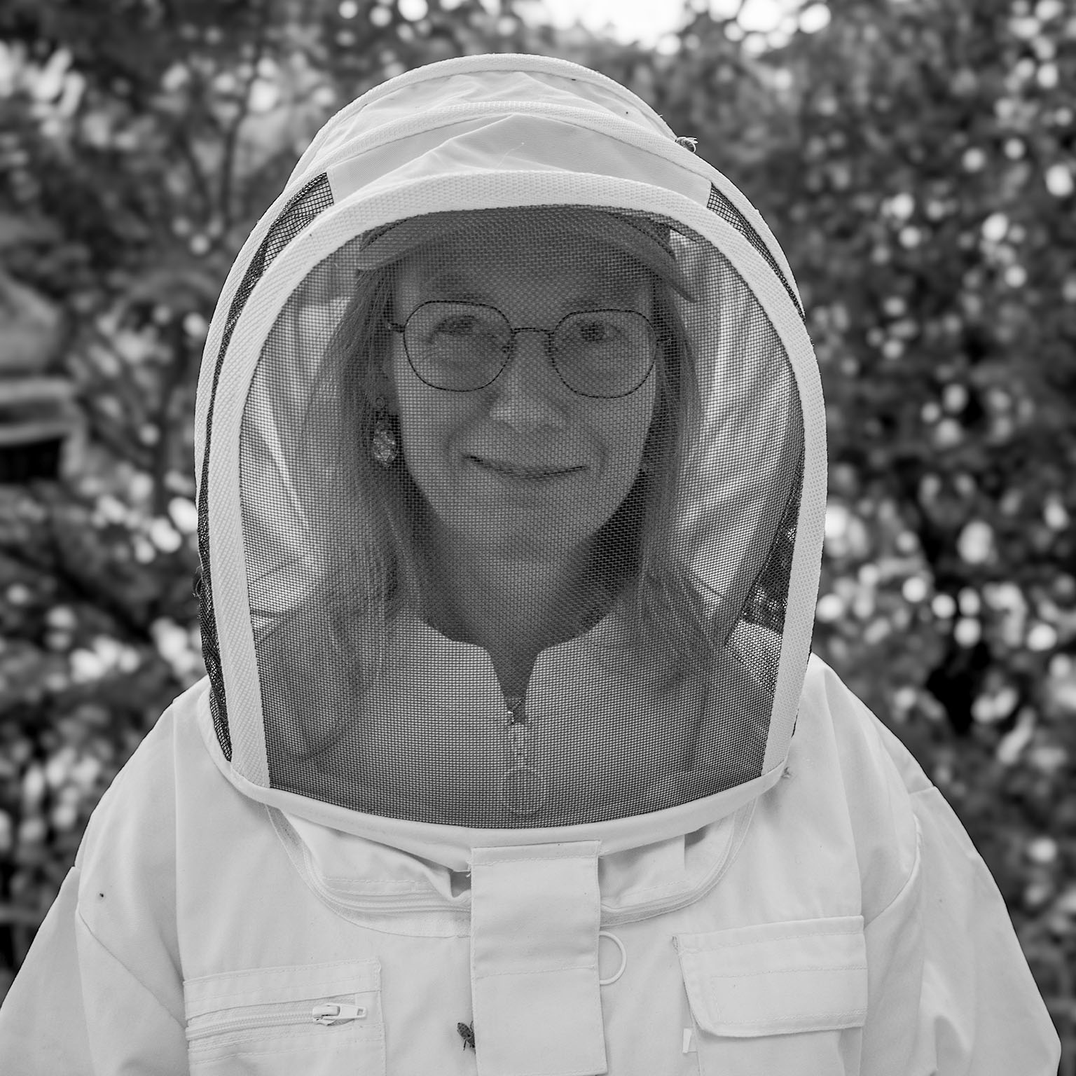 Portrait d'une apicultrice derrière son voile de protection